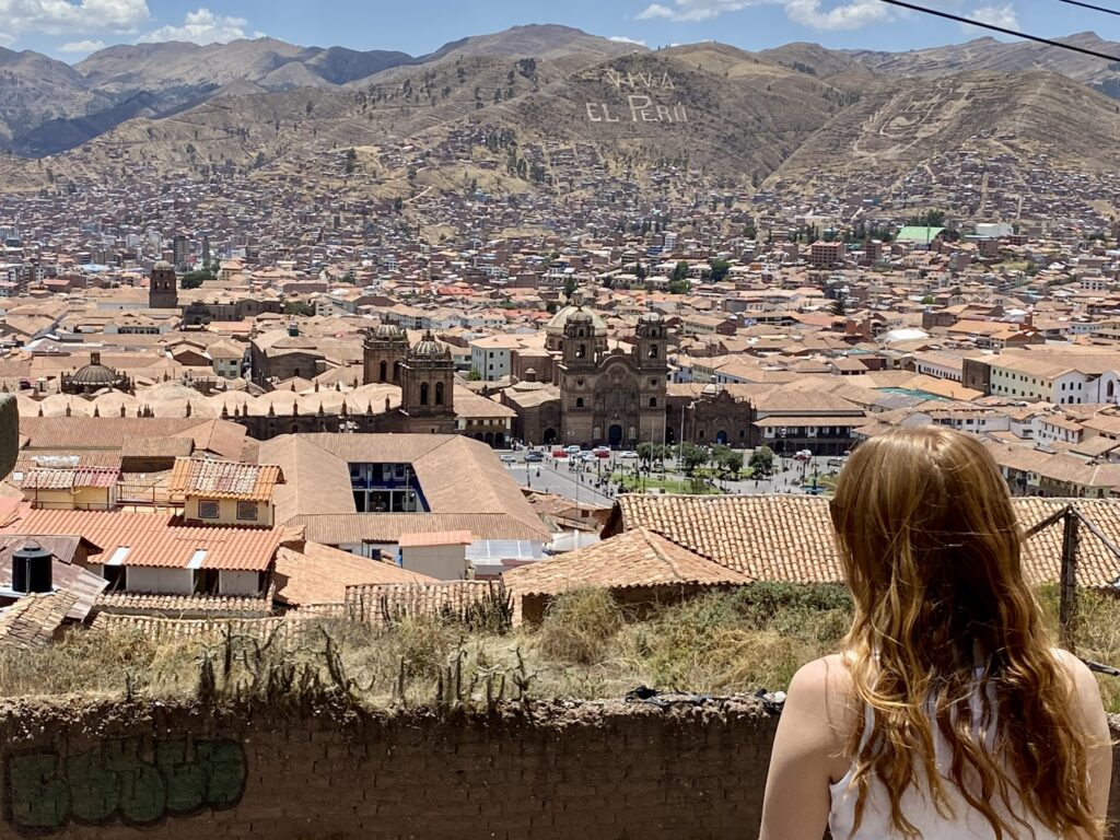 Best Day Hikes from Cusco a woman at the mirador san cristobal in cusco, peru